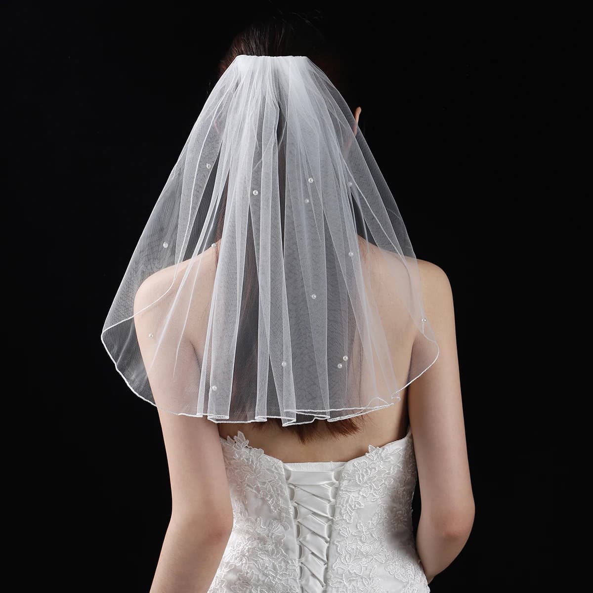 A white elegant bridal veil with a shoulder length veil adorned with simulated pearls, suitable for women's weddings